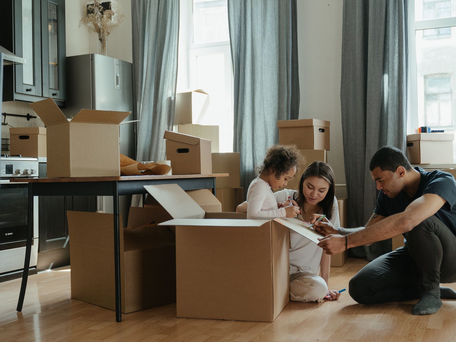 Een gezin pakt samen verhuisdozen in tijdens de verhuizing naar hun nieuwe huis